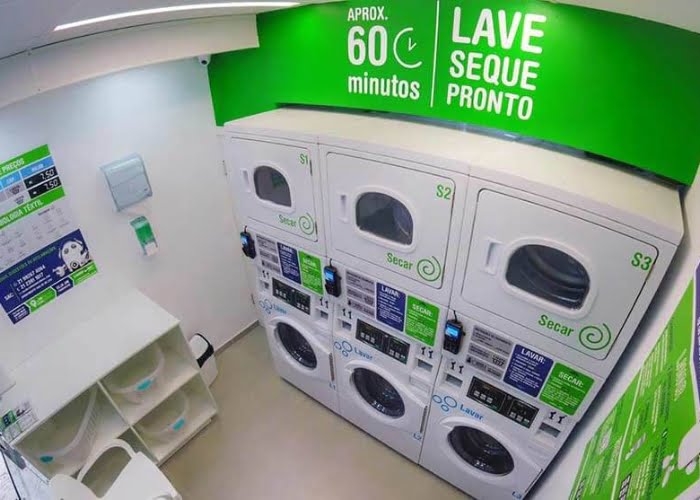 Interior moderno de lavanderia self-service com máquinas de lavar e secar frente a frente