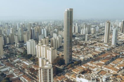 Canteiro de obras em São Paulo com estrutura metálica pré-fabricada e módulos de banheiro sendo instalados por poucos operários