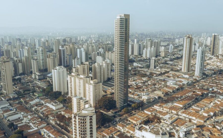 Canteiro de obras em São Paulo com estrutura metálica pré-fabricada e módulos de banheiro sendo instalados por poucos operários
