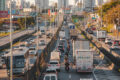 Rodovia brasileira em obras com placa de concessão pública-privada simbolizando investimentos atrasados