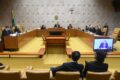Mãe adotiva abraçando bebê diante do STF simbolizando nova igualdade na licença-maternidade