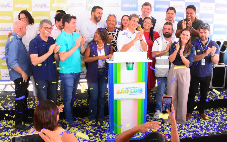 Multidão em comício de campanha eleitoral nas ruas de São Luís, Maranhão, com bandeiras partidárias e candidatos