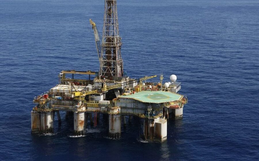 Logos da TotalEnergies e Mistral AI sobre fundo de dados geológicos e plataformas de petróleo