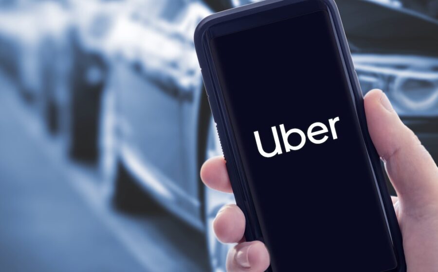 Rodovia deserta à noite com veículo da Uber estacionado e passageira abandonada no acostamento