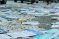 Santinhos eleitorais espalhados no chão de rua urbana, simbolizando crime eleitoral e risco ambiental