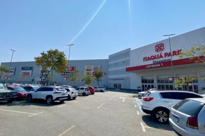 Vista aérea de shopping center movimentado no Alto Tietê com lojas e estacionamento cheio