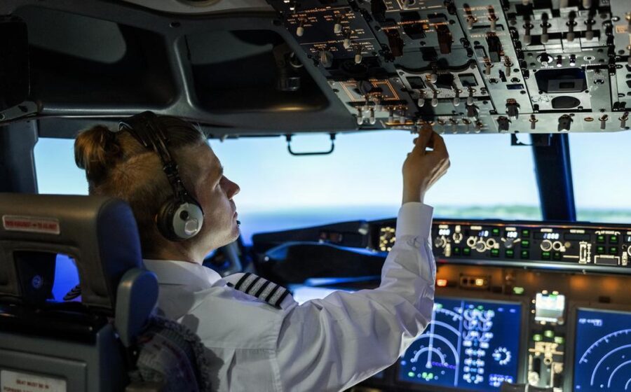 Duas pilotos brasileiras em uniforme de aviação, uma junto a cockpit de Airbus A350 e outra ao lado de carga com cavalos