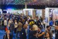 Corredores lotados da Abav Expo 2026 em São Paulo com estandes de turismo e executivos networking