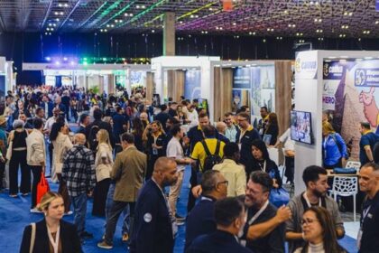 Corredores lotados da Abav Expo 2026 em São Paulo com estandes de turismo e executivos networking