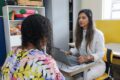 Funcionária do Banco do Brasil acolhe mulher em agência bancária, simbolizando rede de proteção contra violência