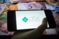 Smartphone exibindo interface do Pix com botão de bloqueio de ofertas de crédito e painel de dívidas