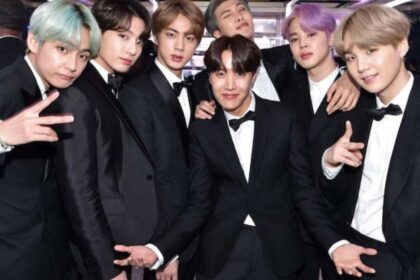 BTS se apresentando no estádio Morumbis lotado com fãs brasileiros agitando lightsticks roxos