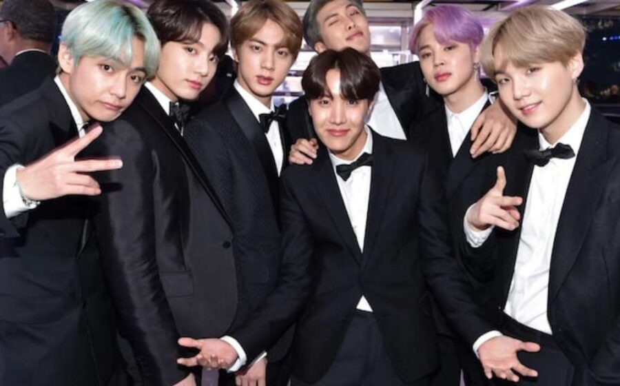 BTS se apresentando no estádio Morumbis lotado com fãs brasileiros agitando lightsticks roxos