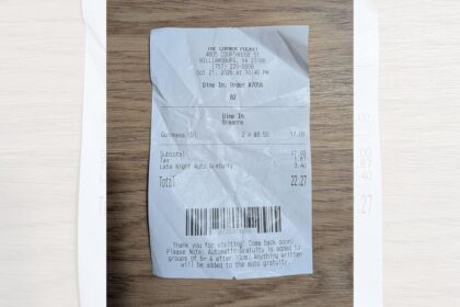 Recibo de bar mostra taxa automática de 20% aplicada após 22h para duas cervejas totalizando US$ 3,40 extra
