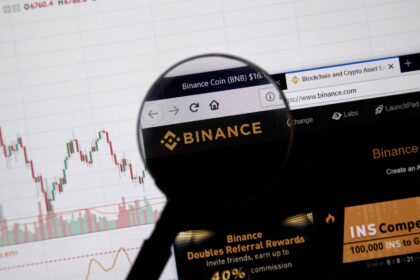 Logotipo da Binance com símbolo de cadeado indicando saques bloqueados no Brasil após hack