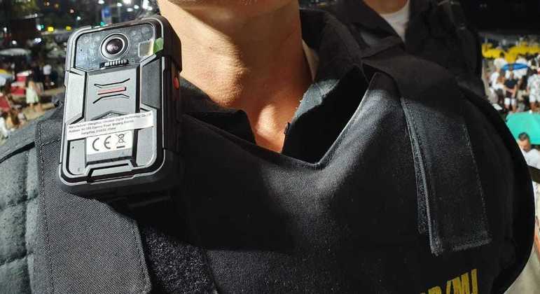 Policial militar do Rio de Janeiro usando câmera corporal na farda durante patrulha urbana