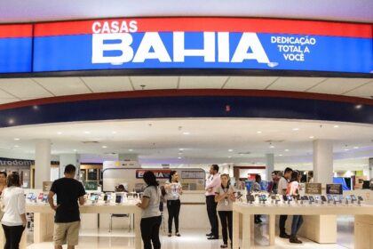 Fachada da loja Casas Bahia com trabalhadores e símbolos de acordo judicial e indenização