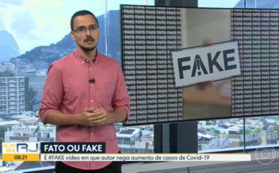 Jornalista verificando fatos em laptop com selo "Checagem" sobre fundo de urnas eletrônicas