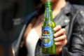 Garrafa verde Heineken 0.0 com rótulo azul e logotipo da estrela vermelha sobre mesa