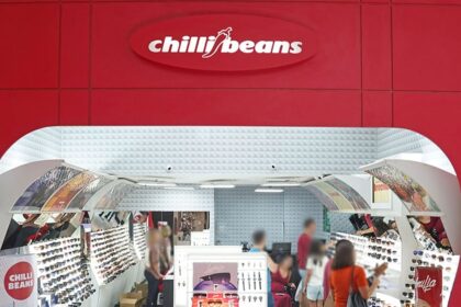 Logotipo da Chilli Beans sobre fundo de loja com óculos escuros expostos, símbolo da recuperação extrajudicial de R$ 340 milhões
