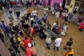 Eleitor vota sob chuva forte em seção eleitoral alagada no Brasil