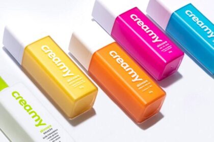 Quatro produtos Creamy skincare minimalistas: limpador, hidratante, protetor solar e complementar sobre fundo neutro