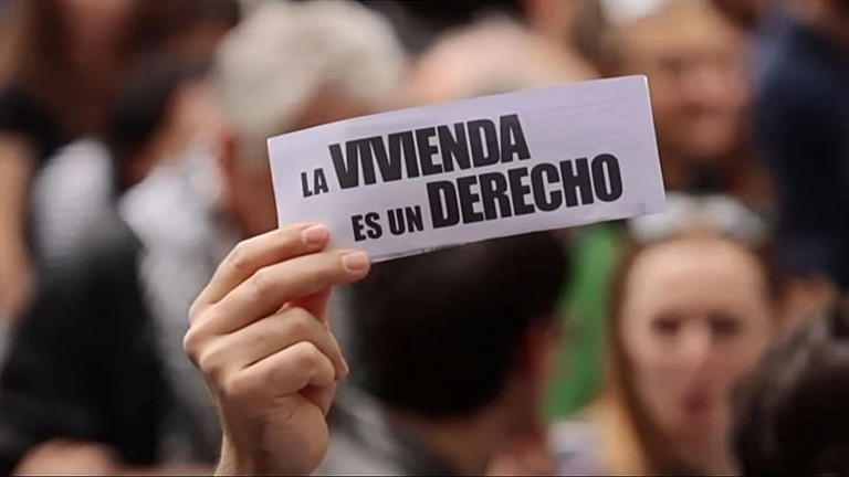 Manifestantes em Madrid seguram cartazes contra crise habitacional na Espanha