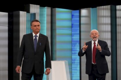 Debate na Globo entre Flávio Bolsonaro e Lula mediado por César Tralli sobre endividamento das famílias brasileiras
