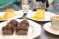 Variadas sobremesas com café em destaque: entremet, brioche e sorvete artesanal em mesa de confeitaria paulistana