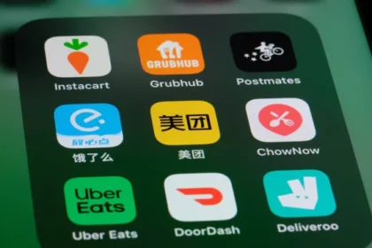 Logos DoorDash e Instacart fundidos com símbolo de dólar e setas de fusão empresarial