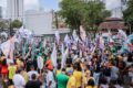 Carreata noturna de campanha eleitoral 2024 com carros adesivados e apoiadores nas ruas iluminadas