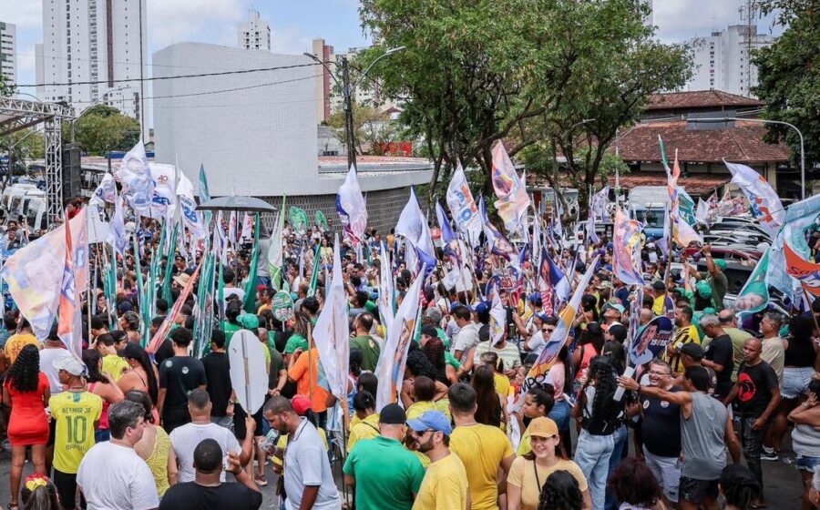Carreata noturna de campanha eleitoral 2024 com carros adesivados e apoiadores nas ruas iluminadas