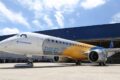 Logotipo da Embraer com gráfico de ações representando mudança de ADR 4:1 para 1:1