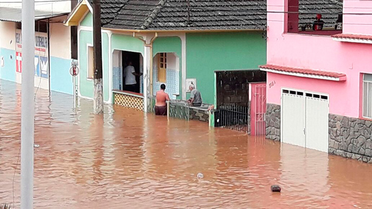 Comerciantes de Juiz de Fora limpando lojas alagadas após enchente histórica de fevereiro de 2026