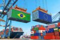 Gráfico de barras mostra crescimento de 21% nas exportações brasileiras para União Europeia com bandeiras do Brasil e UE