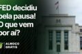 Jerome Powell em coletiva do Fed com gráfico de juros e dólar subindo sobre real brasileiro