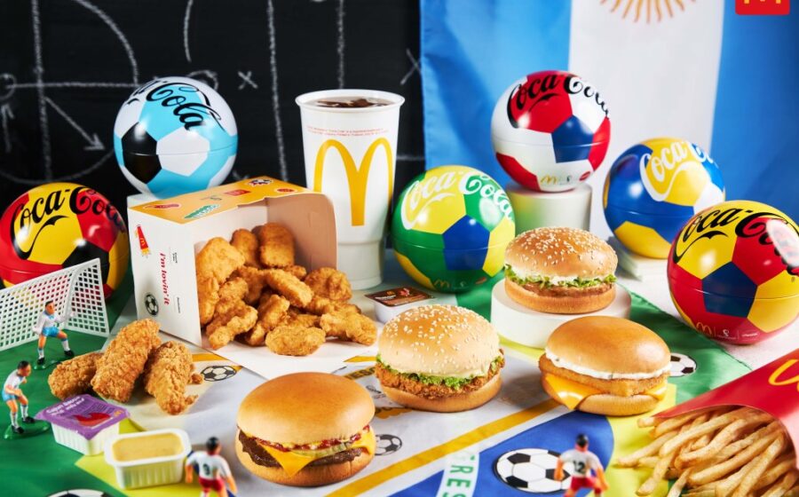 Logotipo do McDonald's (arcos dourados) e brasão da Fifa lado a lado com seta vermelha indicando separação após 32 anos