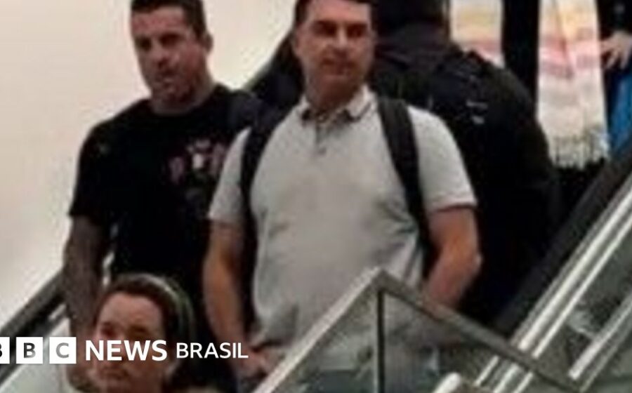 Flávio Bolsonaro em foto oficial de senador, trajando terno escuro e gravata azul