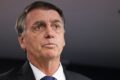 Flávio Bolsonaro discursa ao fundo logotipos da Caixa Econômica e Banco do Brasil
