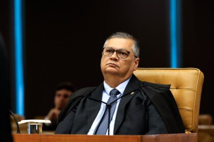 Flávio Dino, ministro da Justiça, em postura serena preparando estratégia para debate na Globo