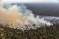 Equipe da Força Nacional do SUS atende pacientes em base móvel na Amazônia com fumaça ao fundo