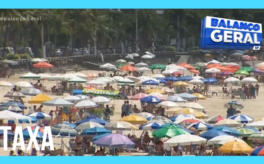 Placa de sinalização da Taxa de Preservação Ambiental na entrada de Guarujá com praia ao fundo