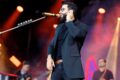 Gusttavo Lima no palco durante show de réveillon com microfone em destaque