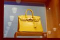 Fachada de loja Hermès com bolsas expostas, simbolizando queda de 6% nas ações após resultados divergentes