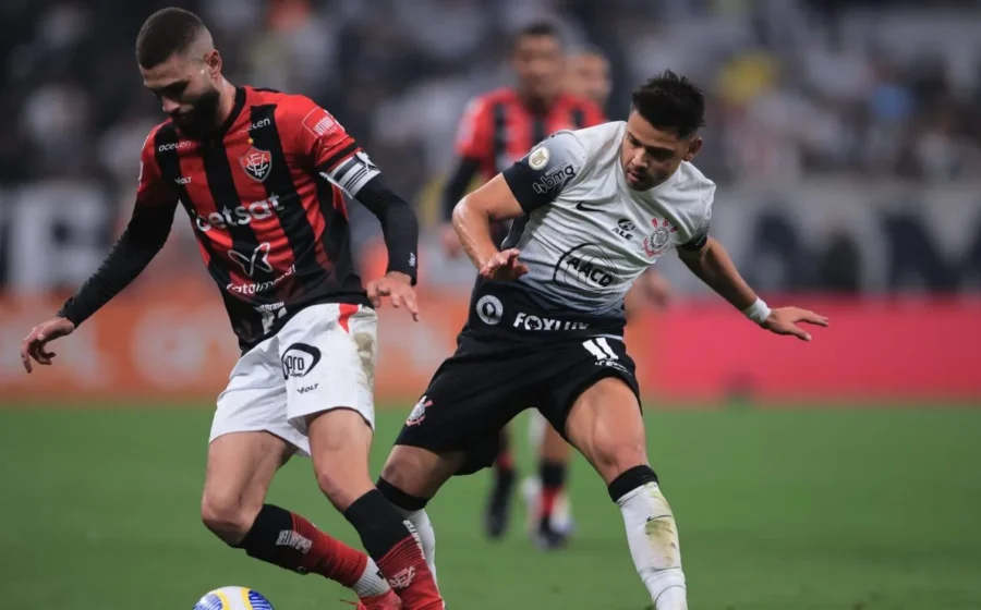 Neo Química Arena à noite com logo do Corinthians e Vitória, ícone de IA prevendo placar 2x1