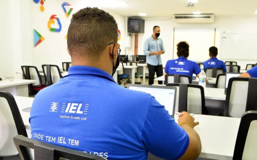 Estudantes em entrevista de estágio com logo do IEL e mapa do Tocantins destacando 25 vagas com bolsa R$ 1,3 mil