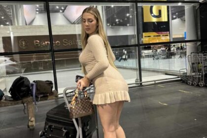 Influenciadora Malévola Alves sorrindo no aeroporto do Egito após liberação, com mala de viagem