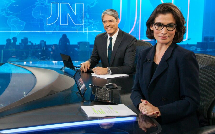 Logotipo do JRO2 ao fundo de estúdio de jornalismo da TV Globo Rio