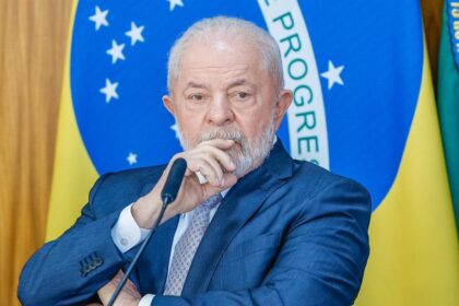 Cadeira vazia de ministro da Fazenda com gráfico de juros altos ao fundo, simbolizando troca de comando sem solução fiscal