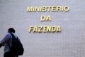 Gráfico de juros altos com silhueta do Ministério da Fazenda ao fundo, simbolizando política monetária rígida
